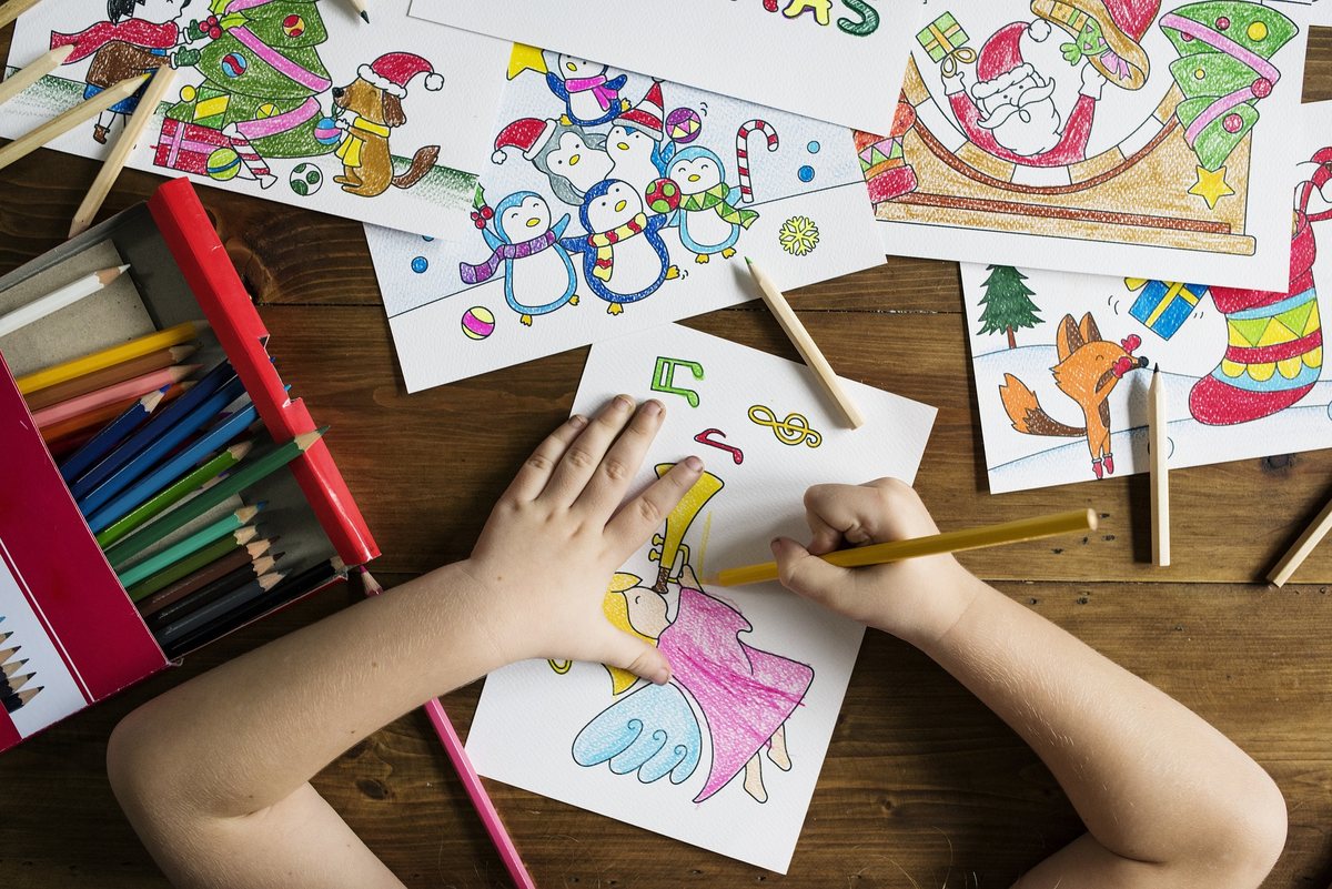 Kinderhände beim Malen mit Buntstiften