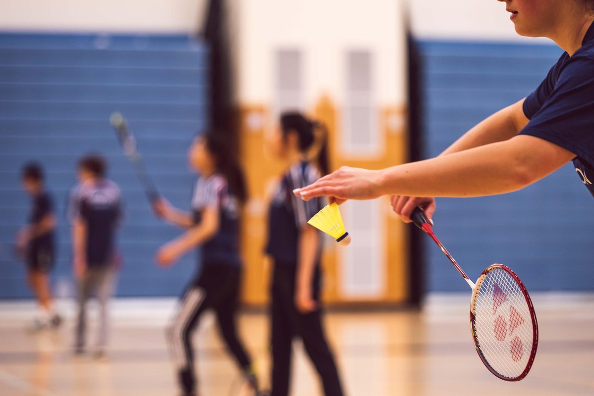 Schülerinnen und Schüler beim Badminton in der Sporthalle